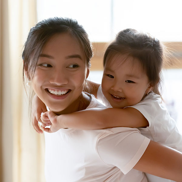 Mother and Daughter smiling in front of a window